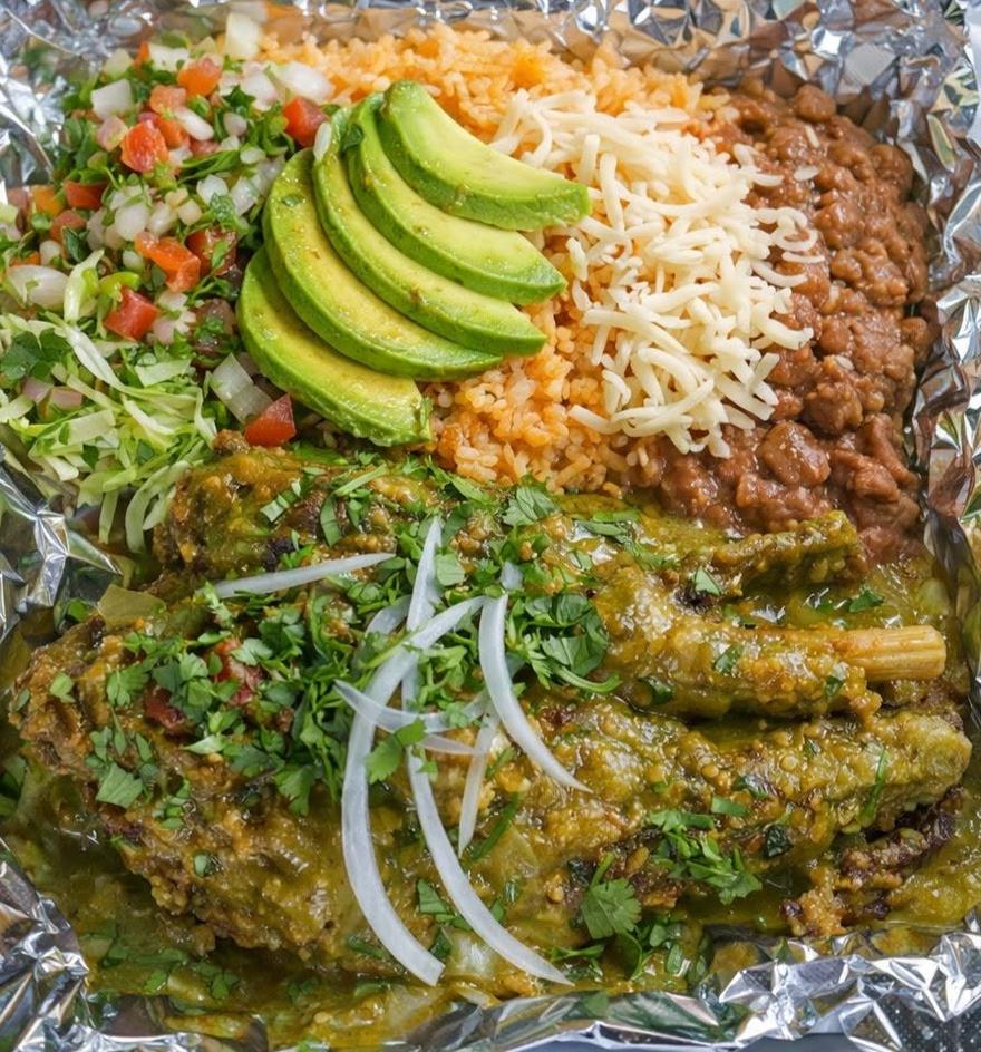A plate of rice, refried beans, sliced avocado, shredded cabbage and pico de gallo